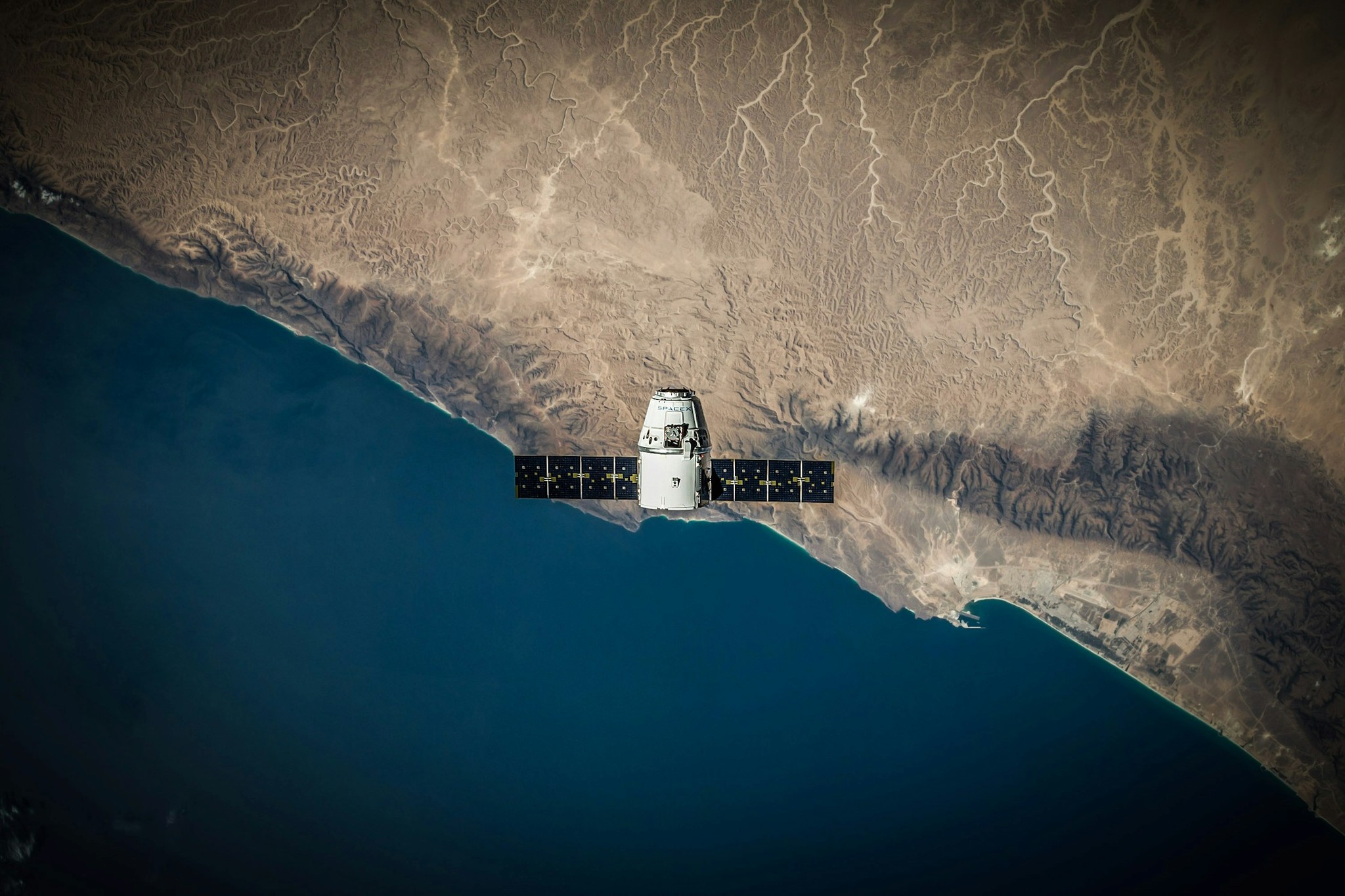 A spacecraft above a coastline seen from orbit